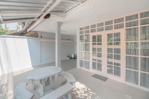 a white bench in a room with windows at Manim House - บ้านพักในนิมมานพร้อมไวไฟ in Chiang Mai