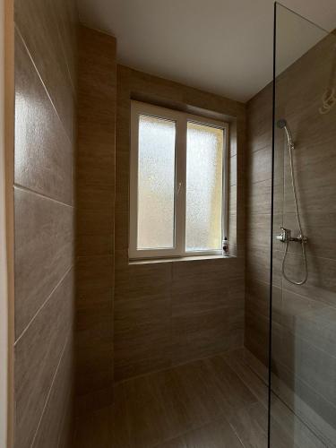a bathroom with a shower and a window at City Comfort Apartment in Bacău