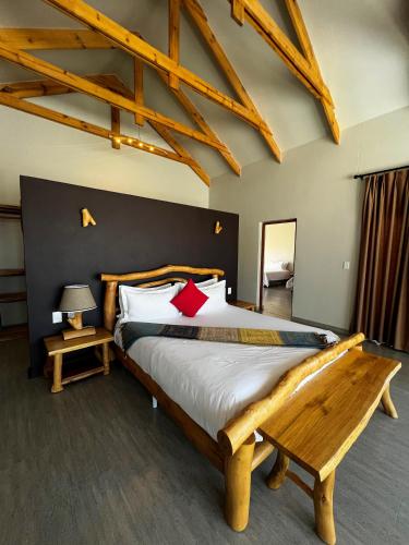 a bedroom with a large bed with a wooden headboard at Agama Lodge in Solitaire