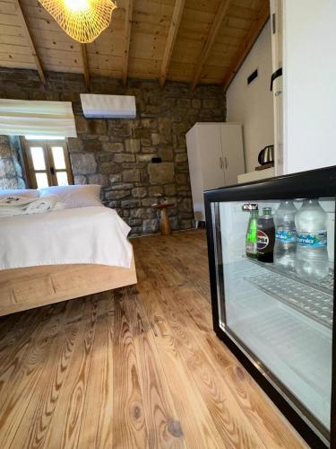 a bedroom with a bed and a refrigerator with drinks at Paleos İmroz in Gökçeada