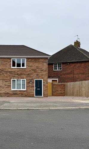 a brick house with a blue door on a street at Campbell House in Lincoln