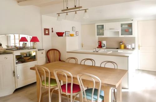 une cuisine avec une table et des chaises en bois dans l'établissement Maison spacieuse à Saint-André-de-Valborgne avec jardin 120 m², à Saint-André-de-Valborgne