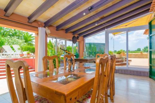 a dining room with a wooden table and chairs at Es Rafal Nostro in Felanitx