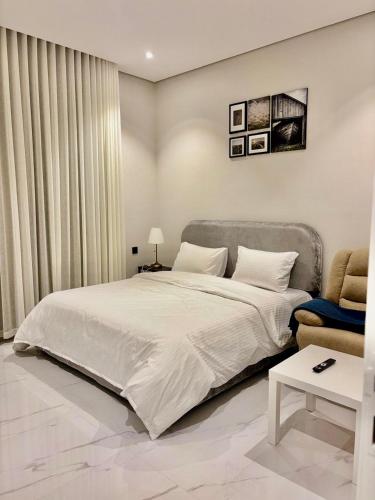 a bedroom with a large white bed and a couch at RIVIERA دخول ذاتي self check-in in Riyadh