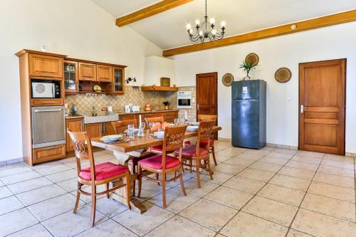 une cuisine avec une table, des chaises et un réfrigérateur dans l'établissement La Maison du Bonheur !, à Graveson
