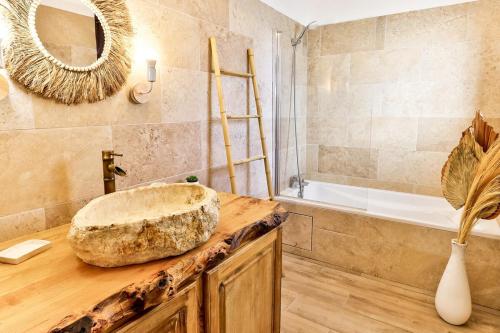 La salle de bains est pourvue d'un lavabo en pierre et d'une baignoire. dans l'établissement La Maison du Bonheur !, à Graveson