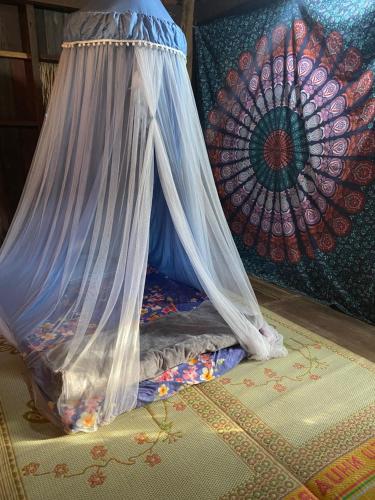 a bed with a net on top of a rug at Berry homestay 1 in Buon Ma Thuot