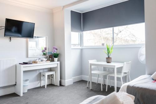 a bedroom with a desk and a table and a bed at 1 Riverside Apartments in Norwich