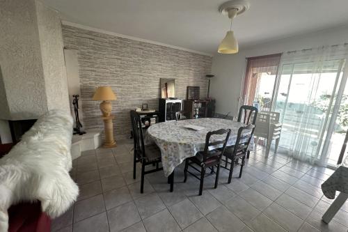 une salle à manger avec une table et des chaises et un chien dans l'établissement House T3 with garden near beach, au Grau-du-Roi