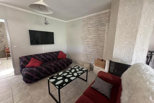 un salon avec un canapé et une télévision dans l'établissement House T3 with garden near beach, au Grau-du-Roi
