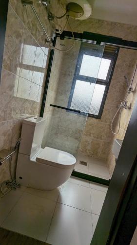 a bathroom with a toilet and a large window at K Hotel Kigali in Kigali