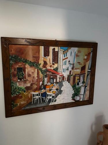 a painting of a street with tables and chairs at La Casa delle Rondini in Baunei