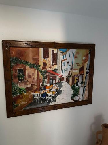 a painting of a street with tables and chairs at La Casa delle Rondini in Baunei