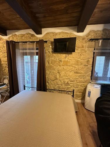 a bedroom with a bed and a tv on the wall at La Casa delle Rondini in Baunei