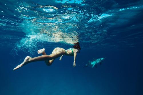 a woman is swimming in the water at Villa Adelaide 22 Pax by VILLASRETREATS in Rometta