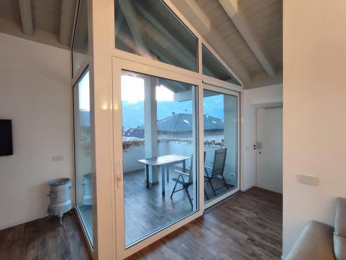 ラヴィースにあるAttico vicino Trento vista montagne mozzafiatoのガラスのドアと景色が見えるテーブルのある部屋