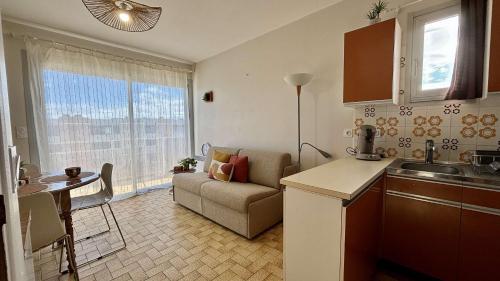 une cuisine et un salon avec un canapé et une table dans l'établissement Appartement 4 personnes - PORT LA NOUVELLE PN650-096, à Port-la-Nouvelle