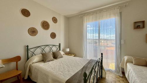 une chambre avec un lit et une grande fenêtre dans l'établissement Appartement 4 personnes - PORT LA NOUVELLE PN650-096, à Port-la-Nouvelle