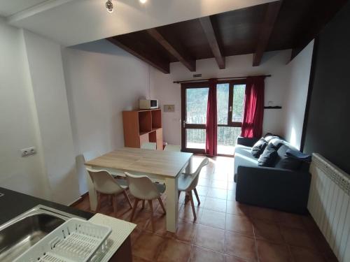 a living room with a table and a couch at Aula Natura La Salle - Cal Cerdanyola in Bagá