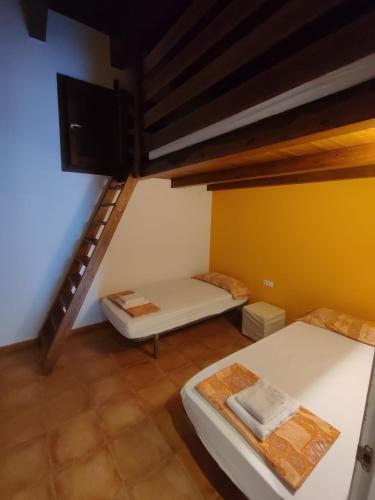 a room with two beds and a staircase at Aula Natura La Salle - Cal Cerdanyola in Bagá