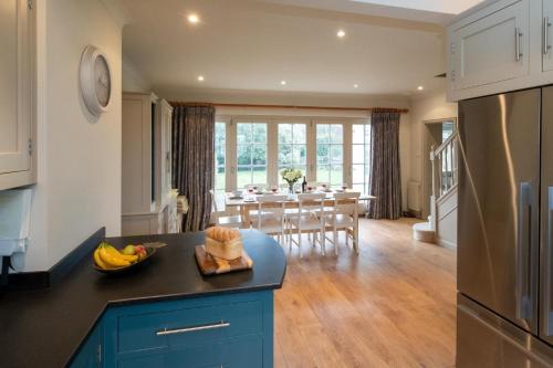 a kitchen and dining room with a table in the background at 3 The Coastguards, Thorpeness - Only a stones throw from the Beach and very close to famous boating Meare, Country Club and Golf Club - Aldeburgh Coastal Cottages in Thorpeness