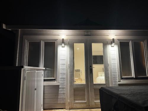 a room with sliding glass doors with a bed at The Grove self-contained Garden Suite in Bexleyheath