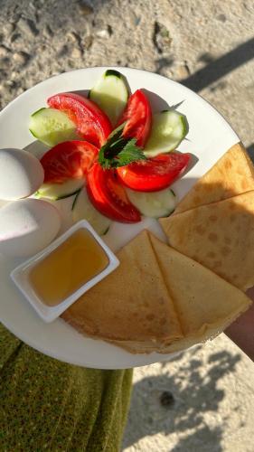 a plate of food with fruit and crackers on it at Green bunny ArtHouse in Martvili