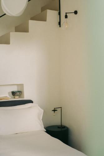 a bedroom with a white bed and a staircase at Dimora delle Balze in Noto