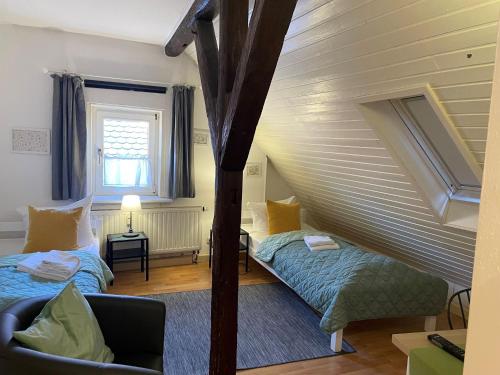 a attic room with two beds and a couch at Gartenlaube Marburg in Marburg an der Lahn