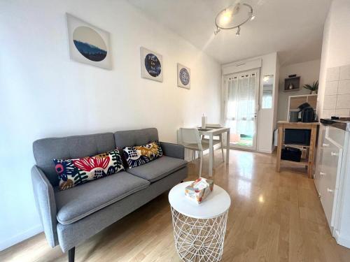 ein Wohnzimmer mit Sofa und Tisch in der Unterkunft Charming T1 - Parking - Metro St Agne in Toulouse