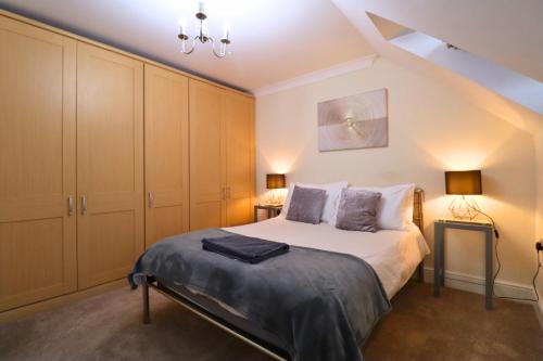 a bedroom with a king sized bed and cabinets at Spacious Bracknell Four Bedroom House in Bracknell