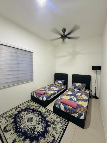 two beds in a room with a ceiling fan at Embun Homestay Puchong SemiD 1-10Pax 6-7CarPark in Puchong