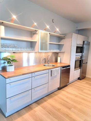 a kitchen with white cabinets and a stainless steel refrigerator at IM Apartments - with private jacuzzi and sauna in the heart of Vaasa in Vaasa