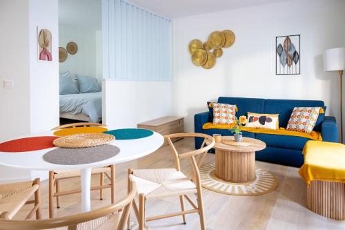 un salon avec une table et un canapé bleu dans l'établissement Rivoli- Quiet apartment, close to Negresco, à Nice