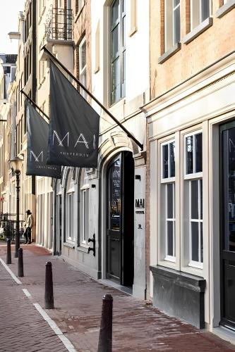 a building with signs on it on a street at Hotel Mai Amsterdam in Amsterdam