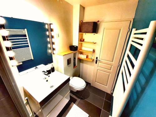 une salle de bain avec des toilettes, un lavabo et une porte dans l'établissement F2 Moderne Confort, Hyper Centre, à Enghien-les-Bains