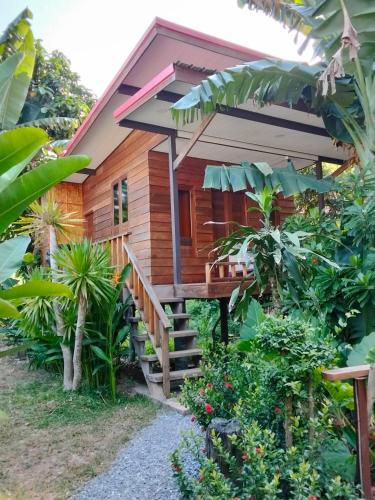 a wooden house with a wooden staircase leading up to it at Rommai Forest Bungalows in Ko Lanta