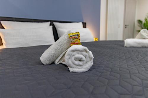 a stuffed animal is laying on a bed at HANNIBAL - Design Studio-Apartment Tulpe 9, Parkplatz, Küche, HighSpeed-WLAN in Wolfsburg