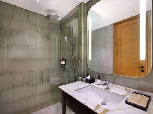 a bathroom with a sink and a mirror at Mercure Garut City Center in Garut