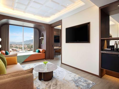 a living room with a couch and a tv at Mercure Garut City Center in Garut