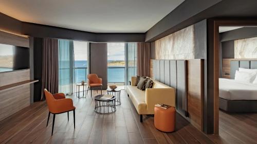 a hotel room with a bed and a couch at AX ODYCY Hotel in St Paul's Bay