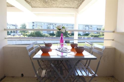 une table avec des bols et un vase sur un balcon dans l'établissement Appt 2 pièces LA ROCHELLE - LR030-E111Z, à La Rochelle