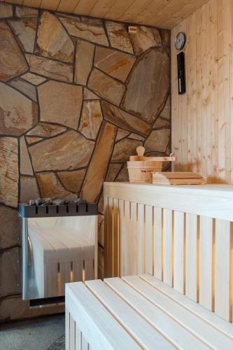 a kitchen with a stone wall and a stove at Kasztanowe Zacisze in Jaworzynka