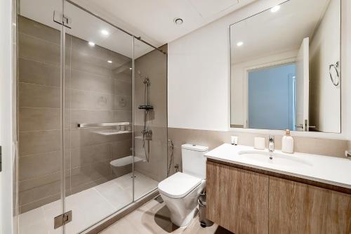 a bathroom with a shower and a toilet and a sink at Premium Apartments at Executive Residences in Dubai