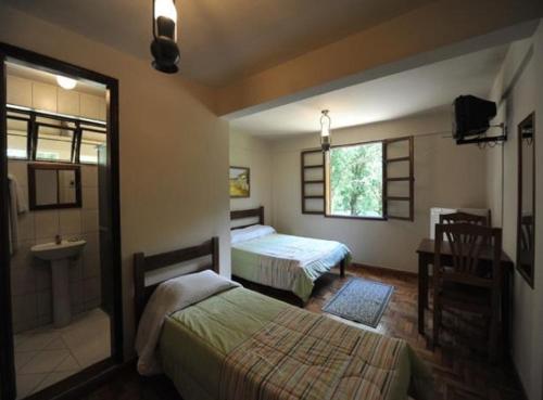 a hotel room with two beds and a sink at Vereda Bike Park Hotel in São João del Rei