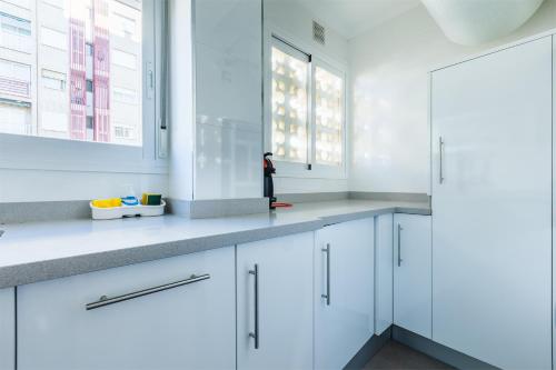a kitchen with white cabinets and a window at A&N San Gerardo 123 in Torre del Mar