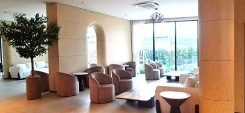 a lobby with chairs and tables and a large window at Viewpoint Khaoyai Hotel in Mu Si