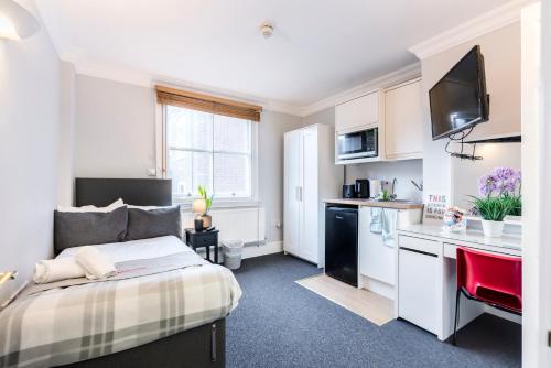 a small bedroom with a bed and a kitchen at 1 Riverside Apartments in Norwich