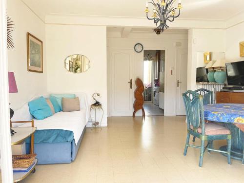 un salon avec un canapé bleu et une table dans l'établissement Charming Apartment in the Heart of Cannes - 10 Minutes walk to La Croisette, à Cannes