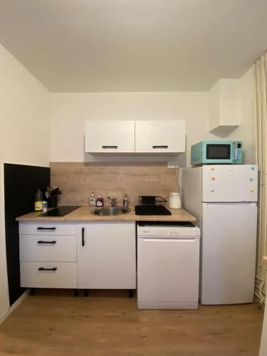 Il comprend une cuisine équipée d'appareils électroménagers blancs et d'un réfrigérateur blanc. dans l'établissement Maison lumineuse, à Chef-Boutonne